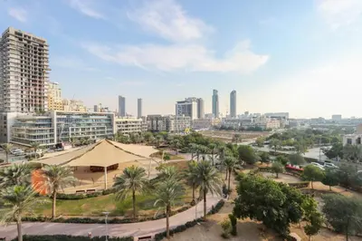 a view of a city with palm trees and buildings at Livbnb - Homey 1B with Spacious Terrace in District 14, JVC in Dubai