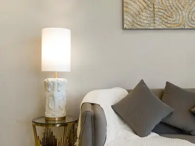 a lamp on a table next to a couch with pillows at Lux Apartments in BusinessBay, Canal views, Great Location in Dubai