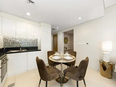 a kitchen and dining room with a table and chairs at Lux Apartments in BusinessBay, Canal views, Great Location in Dubai