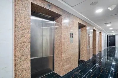 a row of stalls in a restroom with a metal elevator at Newly Built Studio - Urban Living in Dubai