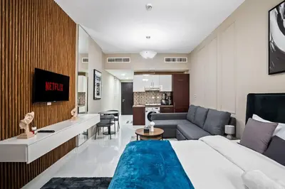 a hotel room with a king sized bed and a living room at Newly Built Studio - Urban Living in Dubai