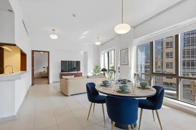 a living room with a table and blue chairs at Exquisite centrally located 1BR in Downtown Dubai in Dubai