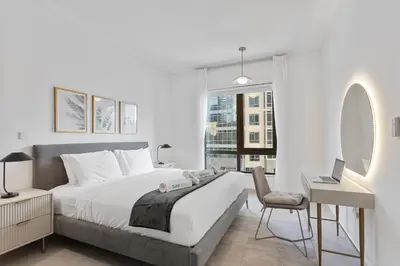 a bedroom with a bed and a desk and a chair at Exquisite centrally located 1BR in Downtown Dubai in Dubai