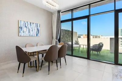 a dining room with a table and chairs at NEW! Spacious 2BHK with Maids room - JVC in Dubai