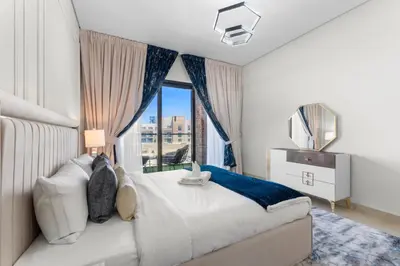 a bedroom with a large bed with a window at NEW! Spacious 2BHK with Maids room - JVC in Dubai