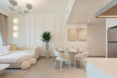 a white living room with a table and a couch at Bright and Exquisite 1-Bedroom in Downtown views 2 in Dubai