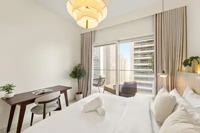 a hotel room with a bed and a desk and a window at Elegant 2BR with Palm & Sea View l Direct Beach Access in Dubai