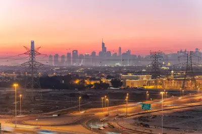 a city skyline at sunset with a highway and street lights at Full Dubai Skyline View LUX 1 BR JVC in Dubai