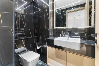 a bathroom with a toilet and a sink and a mirror at Full Dubai Skyline View LUX 1 BR JVC in Dubai
