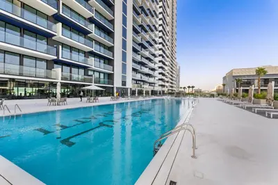 a swimming pool in front of a building at Full Dubai Skyline View LUX 1 BR JVC in Dubai