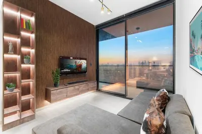 a living room with a couch and a large window at Full Dubai Skyline View LUX 1 BR JVC in Dubai