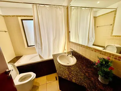 a bathroom with a sink and a toilet and a tub at Bahar 6 in Dubai