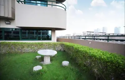a white table in the grass in front of a building at The Junction Partition Room In Barsha Heights in Dubai