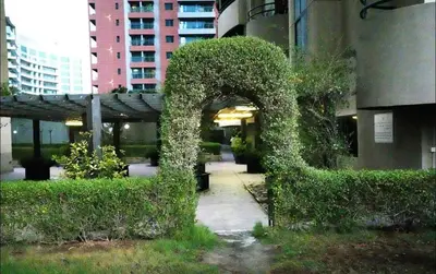 an arch covered in ivy next to a building at The Junction Partition Room In Barsha Heights in Dubai