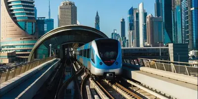 a blue and white train on the tracks in a city at Rest Partition Room in Tecom Near Metro in Dubai