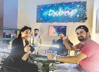 a group of people sitting around a table playing chess at Rest Partition Room in Tecom Near Metro in Dubai