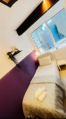 a bedroom with a bed and a large window at Ideal Partition Room in Barsha 1 Near Metro in Dubai