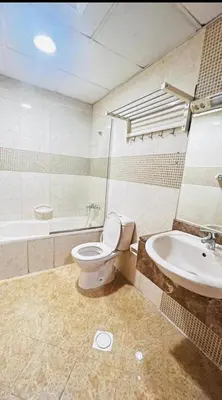 a bathroom with a toilet and a sink and a tub at Ideal Partition Room in Barsha 1 Near Metro in Dubai