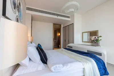 a white bedroom with a large bed and a mirror at Elegant 2BR Apt Address Beach Resort in Dubai