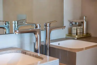 a bathroom with a sink and two faucets at Elegant 2BR Apt Address Beach Resort in Dubai