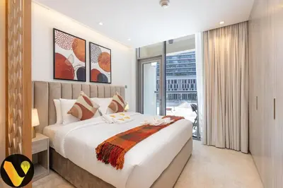 a bedroom with a large bed and a large window at Vogue Downtown The Sterling by Omniyat, near Burj Khalifa and Dubai Mall, Studio Apartment with Balcony and Access to all Amenities in Dubai