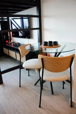 a dining room with a glass table and two chairs at Modern Studio 15mins away From World Trade Center in Dubai