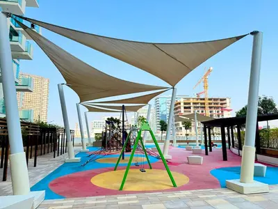 a playground with a swing set under a canopy at Modern Studio 15mins away From World Trade Center in Dubai