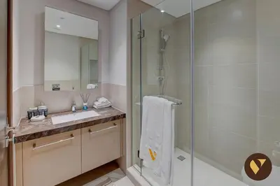 a bathroom with a shower and a sink at Vogue Downtown Boulevard Heights near Dubai Mall and Burj Khalifa, Two Bedroom Apartment with balcony and Access to all Amenities in Dubai