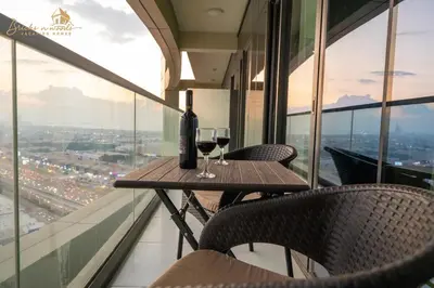 a table with two glasses of wine on a balcony at CHIC Sea View 2Bhk 4pax in Dubai