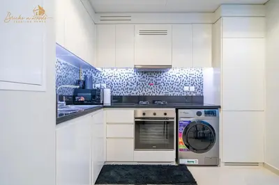 a kitchen with white cabinets and a dishwasher at CHIC Sea View 2Bhk 4pax in Dubai