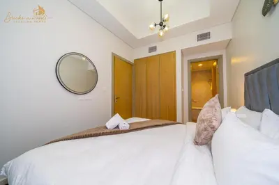 a bedroom with a large white bed with a mirror at CHIC Sea View 2Bhk 4pax in Dubai