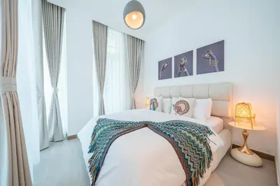 a bedroom with a white bed with a blanket on it at Sleek and Stylish 1BR Fully Furnished Apt in Dubai