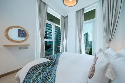 a bedroom with a white bed and a window at Sleek and Stylish 1BR Fully Furnished Apt in Dubai