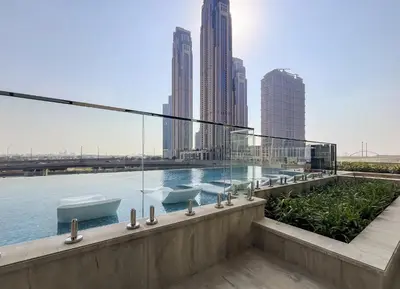 a building with a swimming pool with a view of the city at Sleek and Stylish 1BR Fully Furnished Apt in Dubai