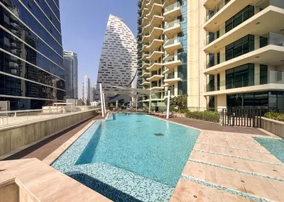 a swimming pool on the roof of a building with tall buildings at Sleek and Stylish 1BR Fully Furnished Apt in Dubai