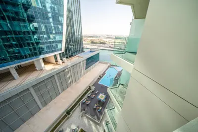 a view from the top of a building with a pool at Sleek and Stylish 1BR Fully Furnished Apt in Dubai