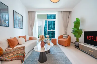 a living room with a couch and a table at Sleek and Stylish 1BR Fully Furnished Apt in Dubai