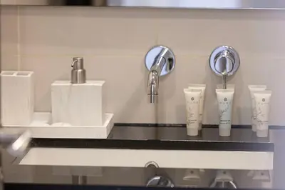 a bathroom counter with two sinks and two faucets at Beautiful 2 BR Apartment next to Opera I Burj View in Dubai