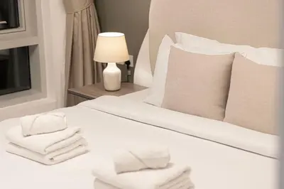 a bedroom with a white bed with towels on it at Beautiful 2 BR Apartment next to Opera I Burj View in Dubai