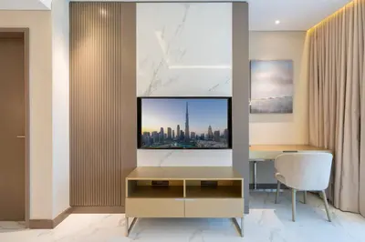 a living room with a desk and a television at Kempinski Central Avenue Residence 1BR- Direct access to Dubai Mall in Dubai