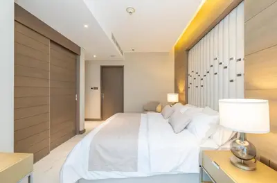 a bedroom with a large white bed and a lamp at Kempinski Central Avenue Residence 1BR- Direct access to Dubai Mall in Dubai