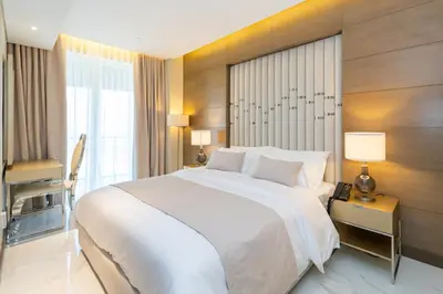a bedroom with a large white bed and a window at Kempinski Central Avenue Residence 1BR- Direct access to Dubai Mall in Dubai