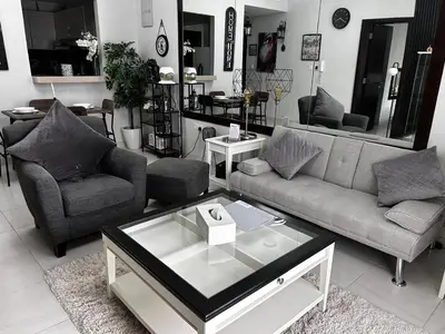 a living room with two couches and a coffee table at The One by Anu in Dubai