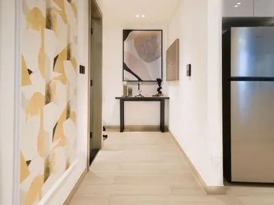 a hallway with a refrigerator and a table at EasyGo- Peaceful 1BDR in Binghatti Heights JVC-01 in Dubai