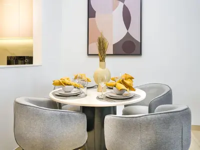 a dining room table with two chairs and a table with a plate of food at EasyGo- Peaceful 1BDR in Binghatti Heights JVC-01 in Dubai