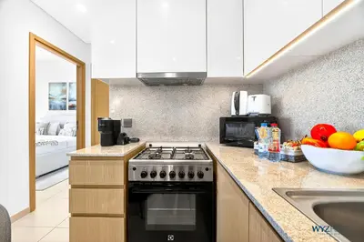 a kitchen with a stove and a bowl of fruit at Sleek 1BR w Canal Views Next to Dubai Mall in Dubai