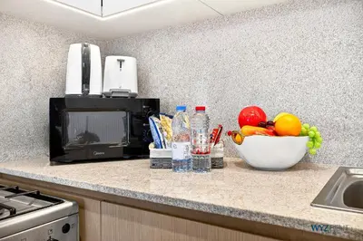 a kitchen counter with a microwave and a bowl of fruit at Sleek 1BR w Canal Views Next to Dubai Mall in Dubai
