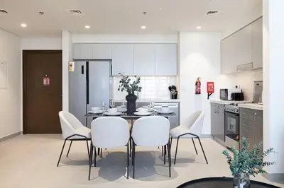 a kitchen with a table and chairs in a kitchen at LUXE - 2BR - Sea & City View - 5 Min to Dubai Mall in Dubai