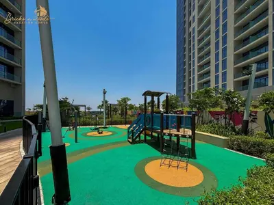a playground with two swings and a slide at Glorious Sea View 3Bhk 6pax in Dubai