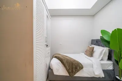 a bedroom with a bed with white sheets and a window at Sea & Sunset View 2Bhk 5pax in Dubai
